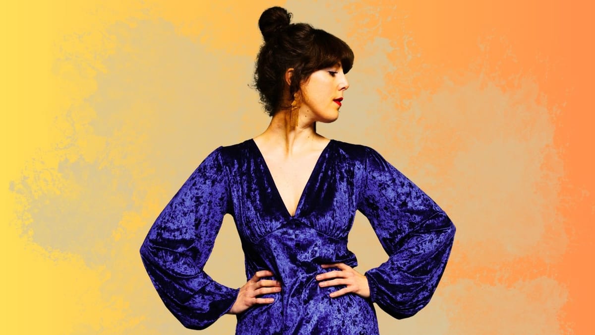 Tine Høeg i blå kjolpå farvet baggrund.