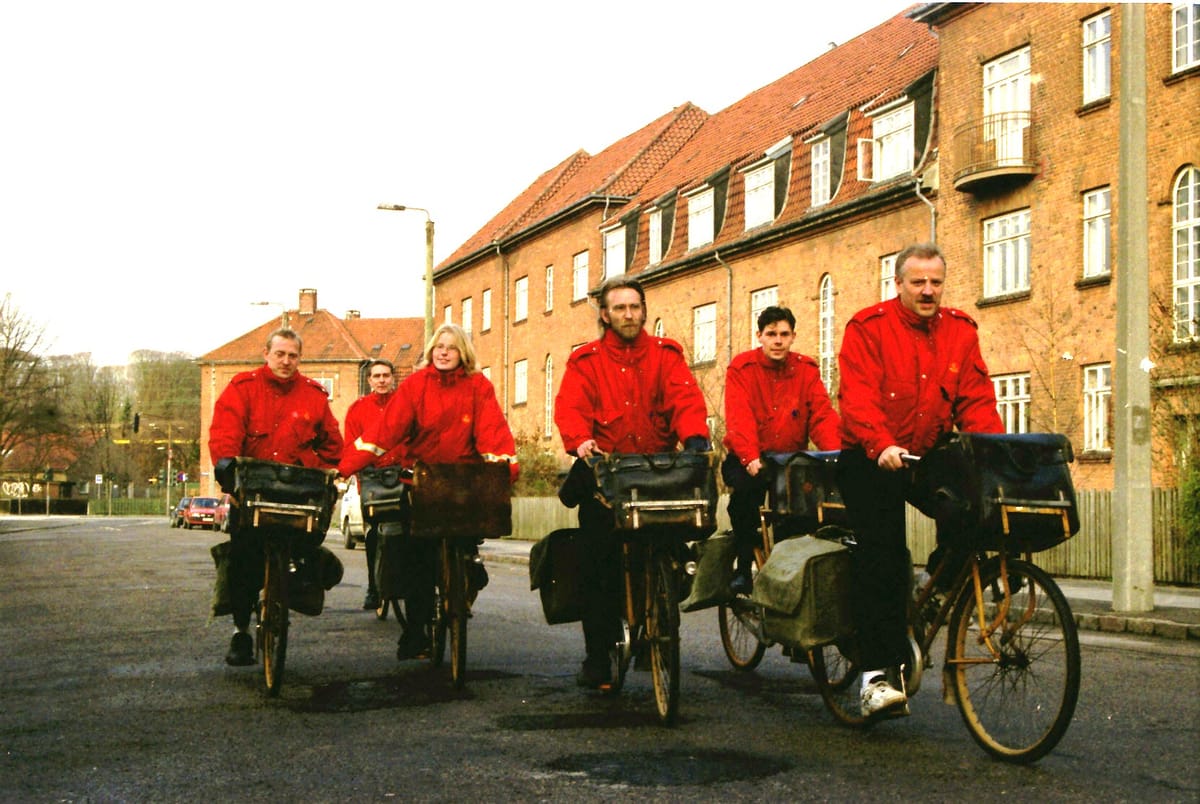 Seks røde cykelbud kører ud med post. Foto fra marts 1998.